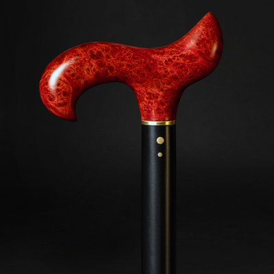 Decorative walking cane with a red handle on a black background