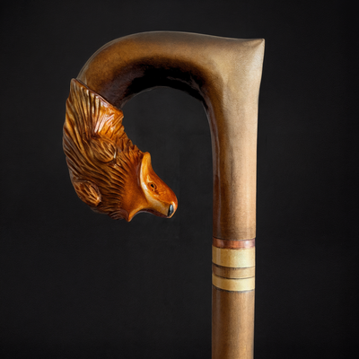Wooden walking cane with a carved fox head handle on a black background